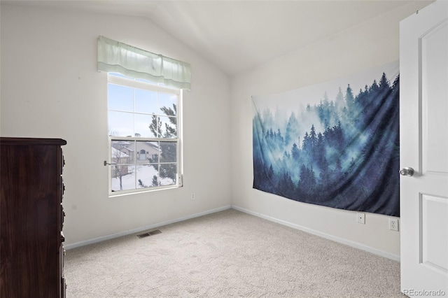 carpeted spare room featuring lofted ceiling