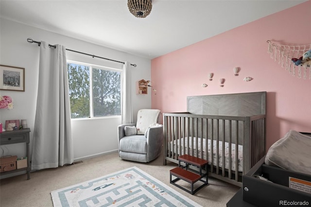 carpeted bedroom featuring a nursery area