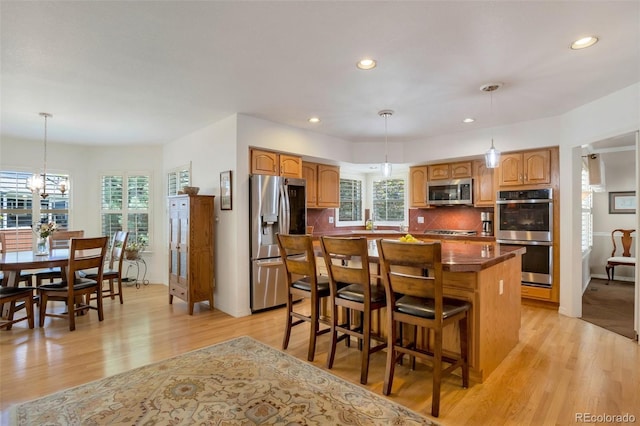 2359 Indian Paintbrush Cir, Highlands Ranch, CO 80129 - kitchen featuring appliances with stainless steel finishes, dark countertops, plenty of natural light, light wood finished floors, and recessed lighting
