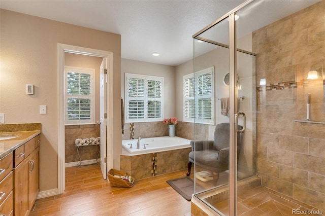 2359 Indian Paintbrush Cir, Highlands Ranch, CO 80129 - bathroom featuring a garden tub, vanity, wood finished floors, and a shower stall