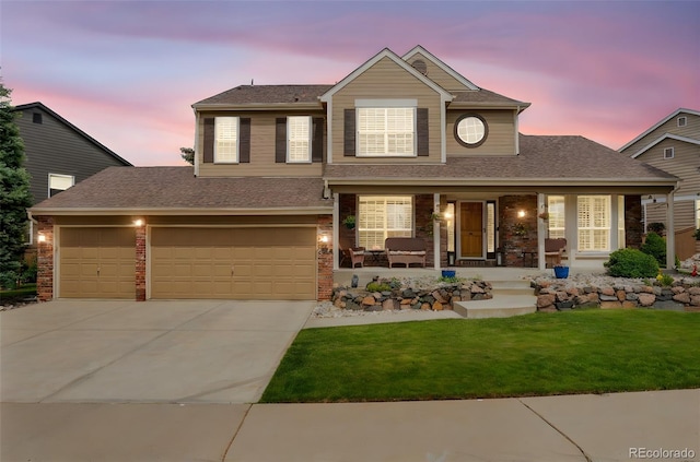 2359 Indian Paintbrush Cir, Highlands Ranch, CO 80129 - traditional home featuring covered porch, concrete driveway, a lawn, roof with shingles, and an attached garage