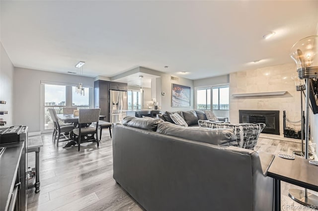 130 N Pearl St Unit 1001, Denver, CO 80203 - living room with a healthy amount of sunlight, a tiled fireplace, light wood-type flooring, and visible vents