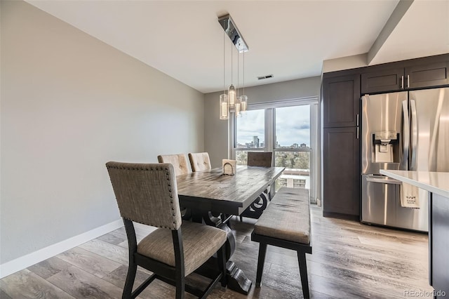 130 N Pearl St Unit 1001, Denver, CO 80203 - dining space with baseboards, an inviting chandelier, light wood-style flooring, and visible vents