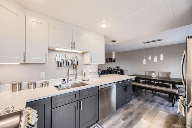 130 N Pearl St Unit 1001, Denver, CO 80203 - kitchen featuring pendant lighting, wood finished floors, light countertops, a sink, and appliances with stainless steel finishes