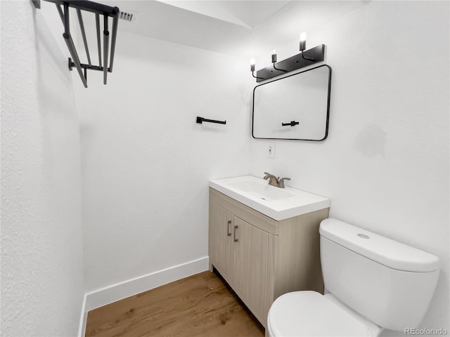 828 Mariposa St, Denver, CO 80204 - half bathroom with wood finished floors, toilet, vanity, and baseboards