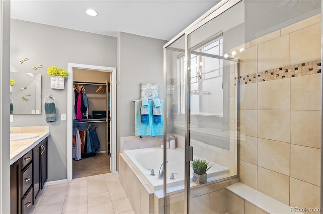 bathroom with tile patterned flooring, vanity, and shower with separate bathtub