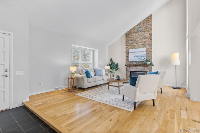 living room with a fireplace, high vaulted ceiling, and wood-type flooring