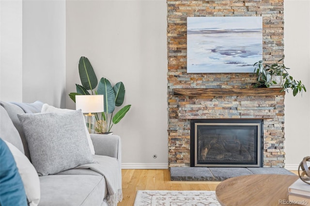 living area with a stone fireplace and light hardwood / wood-style floors