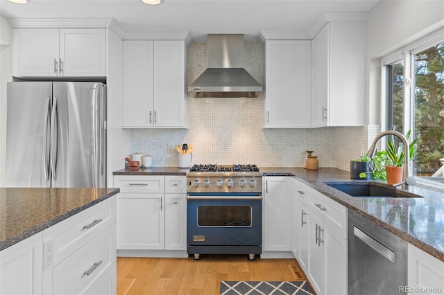 kitchen with white cabinets, stainless steel appliances, and wall chimney range hood