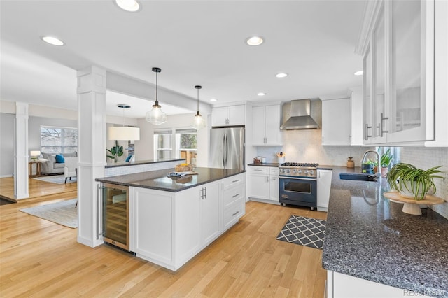 kitchen with white cabinetry, sink, beverage cooler, stainless steel appliances, and wall chimney exhaust hood