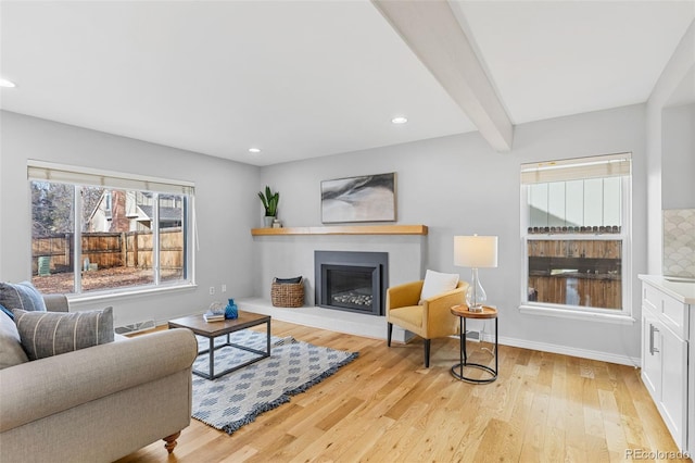 living room with beam ceiling and light wood-type flooring