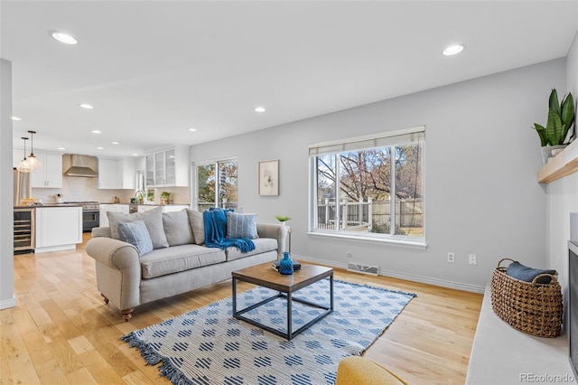 living room featuring sink, beverage cooler, and light hardwood / wood-style floors