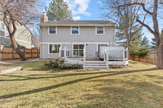 rear view of house with a wooden deck and a lawn