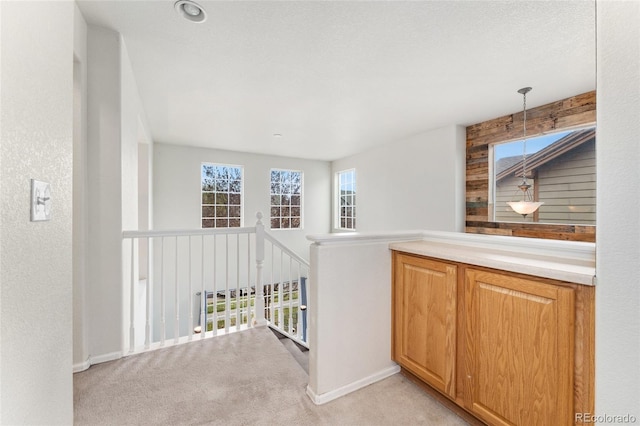 hall featuring light carpet and baseboards