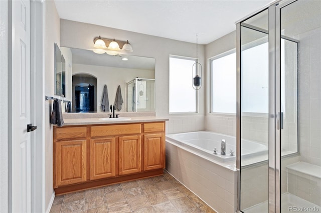 bathroom featuring vanity, a bath, and a stall shower