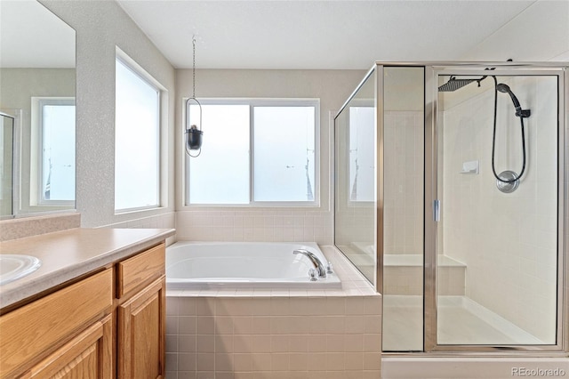 full bathroom featuring a bath, vanity, and a stall shower