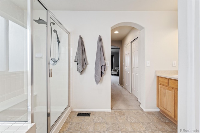 full bathroom featuring baseboards, a stall shower, and vanity