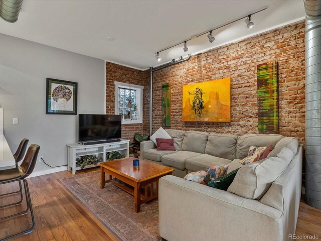 2524 Champa St Unit 1, Denver, CO 80205 - living area with brick wall, wood finished floors, and track lighting