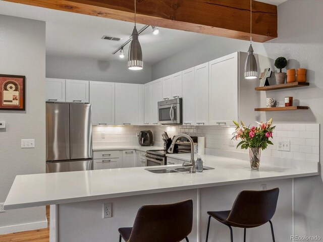 2524 Champa St Unit 1, Denver, CO 80205 - kitchen featuring appliances with stainless steel finishes, a sink, tasteful backsplash, a peninsula, and light countertops