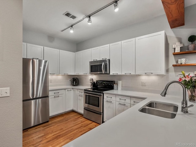 2524 Champa St Unit 1, Denver, CO 80205 - kitchen featuring stainless steel appliances, a sink, light wood-style floors, and light countertops
