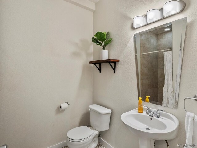 2524 Champa St Unit 1, Denver, CO 80205 - full bathroom featuring baseboards, toilet, tiled shower, and a sink