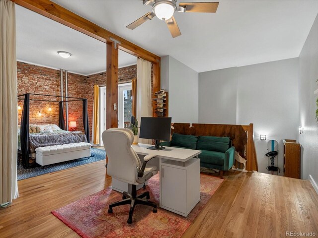2524 Champa St Unit 1, Denver, CO 80205 - home office with wood finished floors, brick wall, and a ceiling fan