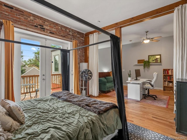 2524 Champa St Unit 1, Denver, CO 80205 - bedroom featuring brick wall, access to outside, wood finished floors, a desk, and baseboards