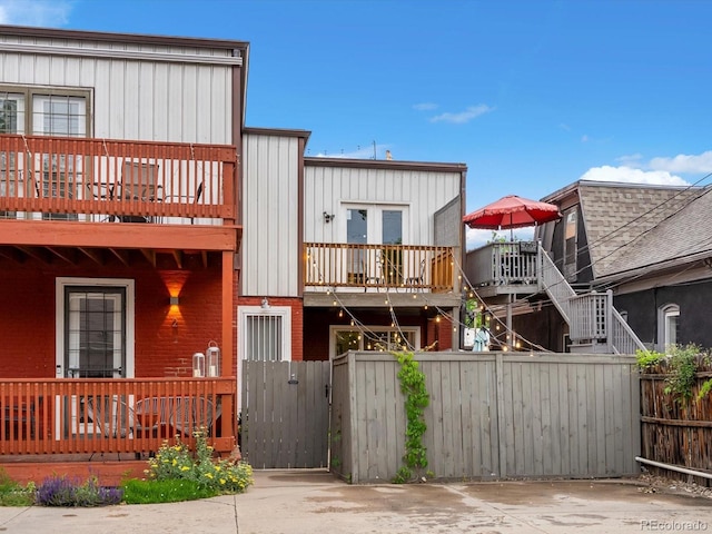 2524 Champa St Unit 1, Denver, CO 80205 - view of front of house with a balcony, a gate, board and batten siding, and brick siding