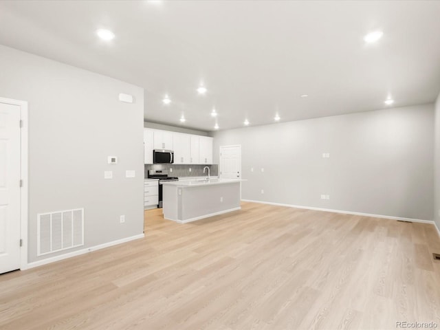 unfurnished living room with sink and light wood-type flooring