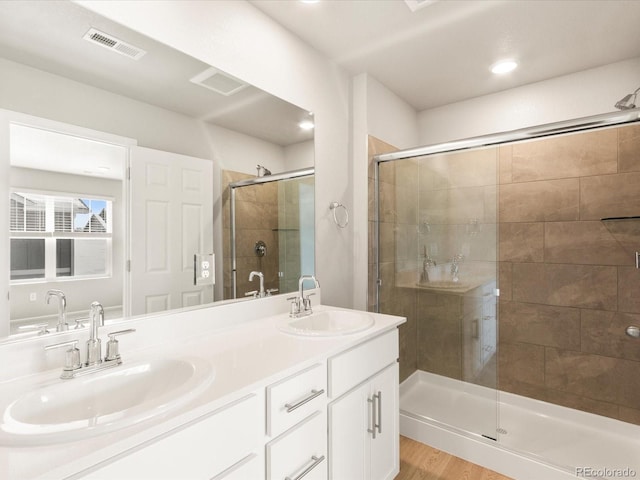 bathroom featuring vanity, hardwood / wood-style floors, and a shower with shower door