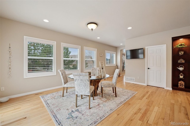 dining room with light wood finished floors, baseboards, and recessed lighting