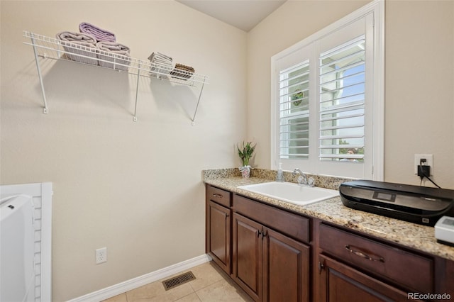 bathroom with vanity, baseboards, and tile patterned flooring