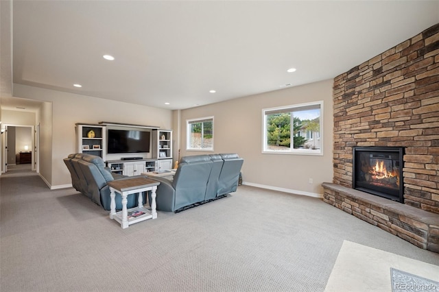 carpeted living area featuring a fireplace, baseboards, and recessed lighting