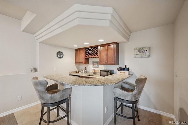 indoor wet bar featuring black microwave, baseboards, light tile patterned floors, and recessed lighting