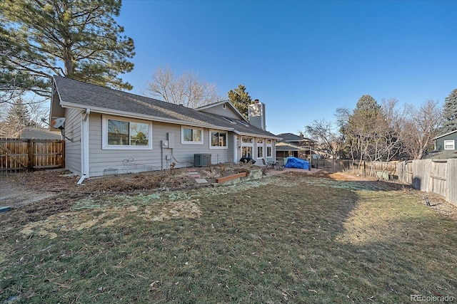 back of property featuring central AC unit and a lawn