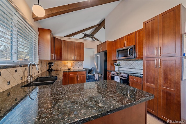 kitchen featuring appliances with stainless steel finishes, sink, dark stone countertops, and decorative light fixtures