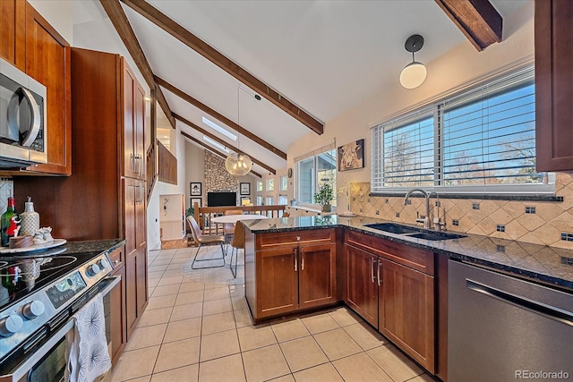 kitchen featuring appliances with stainless steel finishes, sink, pendant lighting, and decorative backsplash