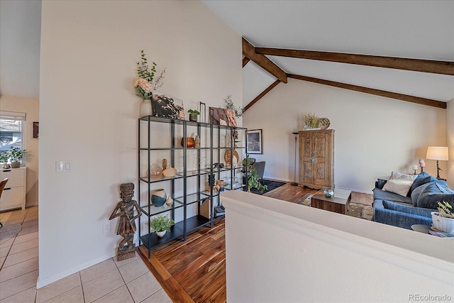 tiled living room featuring vaulted ceiling with beams