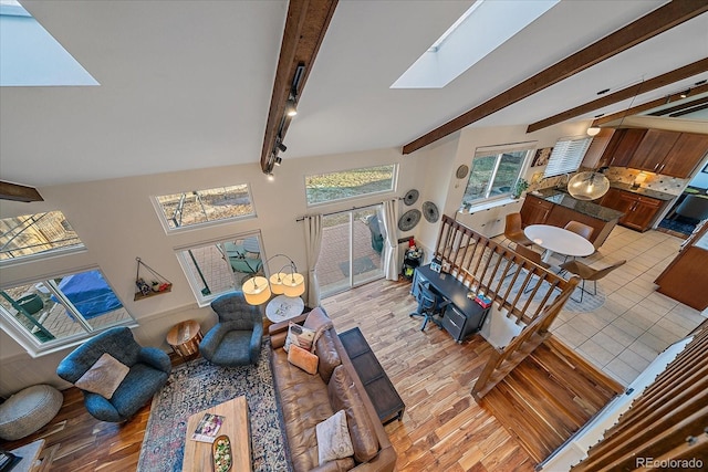 living room with a skylight and beamed ceiling