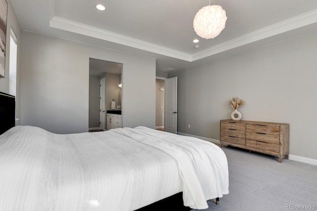 carpeted bedroom featuring a tray ceiling, ensuite bath, crown molding, and a chandelier