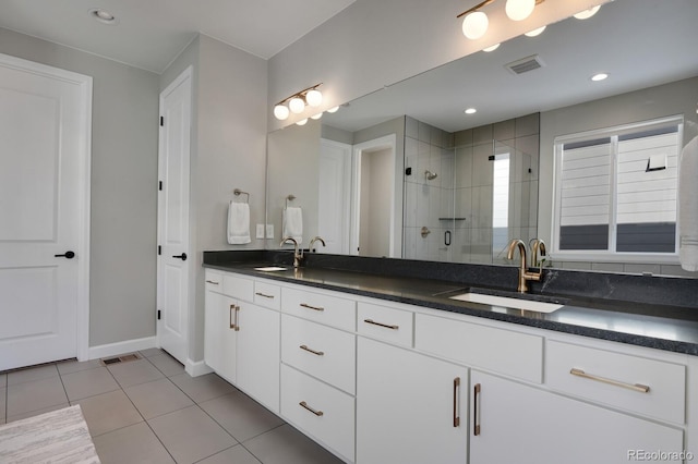 bathroom with tile patterned flooring, vanity, and a shower with shower door