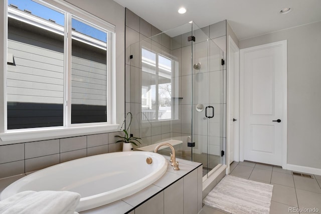 bathroom featuring a healthy amount of sunlight, tile patterned floors, and plus walk in shower