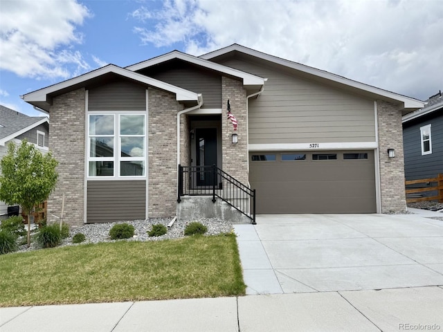 view of front facade featuring an attached garage, concrete driveway, a front yard, and brick siding