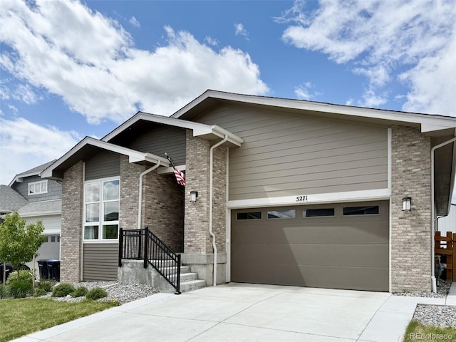 view of front of house featuring an attached garage, concrete driveway, and brick siding