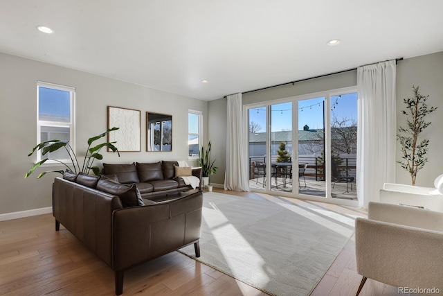 living room featuring recessed lighting, baseboards, and light wood-type flooring
