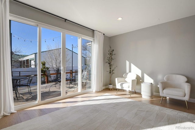 living area featuring recessed lighting, baseboards, and wood finished floors