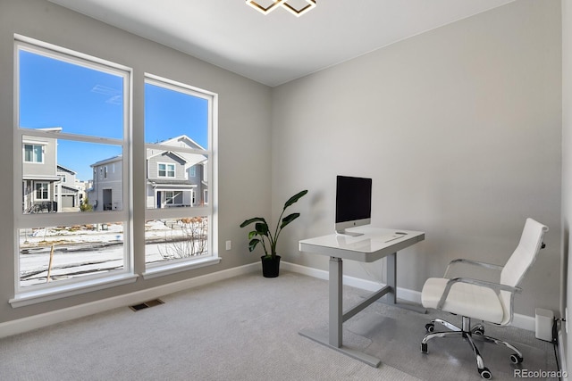 carpeted office space featuring baseboards and visible vents