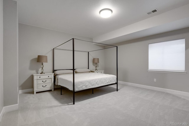 bedroom with baseboards, light carpet, and visible vents