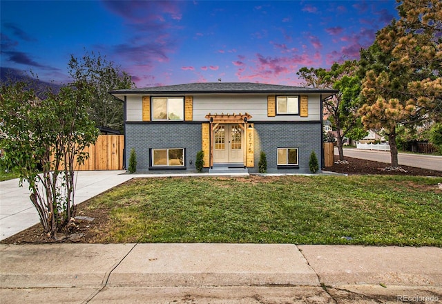 6775 Newland St, Arvada, CO 80003 - split foyer home featuring brick siding, french doors, and concrete driveway