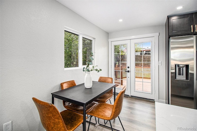 6775 Newland St, Arvada, CO 80003 - dining space with french doors, wood finished floors, recessed lighting, and a textured wall